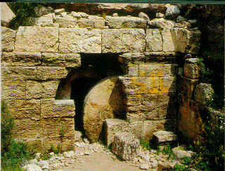 tomb with the stone partially rolled away from the entrance